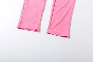 Détail de l'ourlet de la combinaison rose avec coutures soignées et tissu élastique