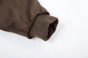 Detaillierte Makroansicht dunkelbrauner Rippbündchen mit präziser Overlock-Naht am Hoodie