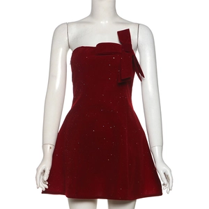 Détail de la robe en velours bordeaux avec paillettes brillantes et un grand nœud sur la poitrine