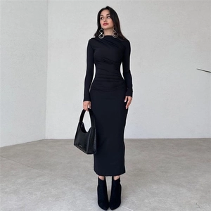 Detail of black slim fit long sleeve midi dress with side ruching and textured fabric