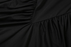 Détail des coutures froncées en V sur une robe longue à col roulé noire élégante