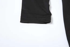 Détail de la manchette à double surpiqûre sur une robe longue moulante noire