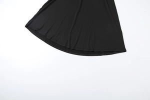 Détail de l'ourlet incurvé et de la couture à double aiguille sur la robe noire