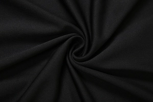 Gros plan sur un tissu en maille noire montrant la texture fine et le drapé élastique
