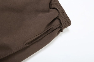 Detail einer dunkelbraunen Strick-Trainingshose mit elastischem Bund und Steppnaht