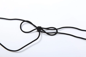 Close-up of the black elastic halter neck strap with an adjustable knot detail on the dress
