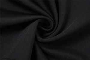 Macro detail of high-density black knitted fabric with soft texture and silky finish