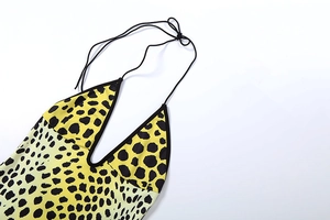 Detail of yellow leopard print halter top showing deep V-neck and black tie-up straps