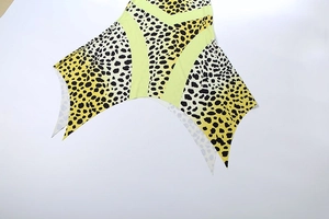 Detail of leopard print dress with neon green patchwork and asymmetric pointed hem