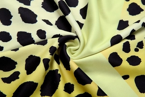 Macro shot of green and yellow gradient leopard print fabric with smooth soft texture