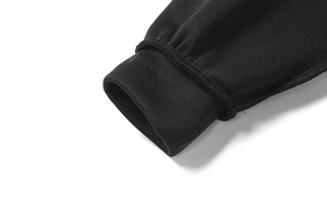Detailaufnahme der gerippten elastischen Bündchen an schwarzem Hoodie und Hose