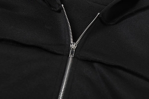 Detailaufnahme des glatten silbernen Metallreißverschlusses an schwarzer Kapuzenjacke