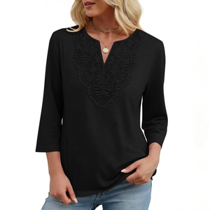 Detail of V-neck lace patchwork and intricate embroidery on a black three-quarter sleeve top