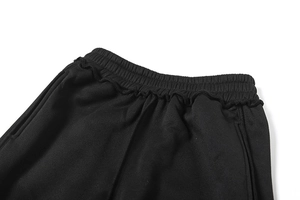 Detail eines breiten elastischen Bundes mit Rüschen und Taschen an einer schwarzen Hose
