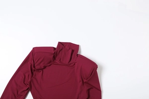 Détail de robe à manches longues et col montant avec épaulettes en tissu rouge vin