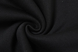 Detailaufnahme des schwarzen Strickstoffs mit Fokus auf Textur und weiche Materialqualität