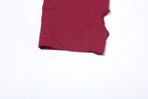 Détail de la manche de robe en maille bordeaux avec trou pour le pouce et couture double