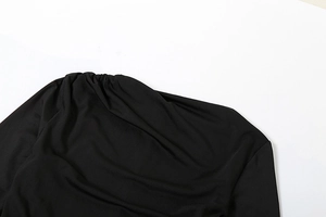Detailed view of the black gathered fabric texture on long sleeve slim fit dress