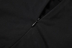 Detailed close-up of a seamless invisible zipper on a black slim fit ribbed dress