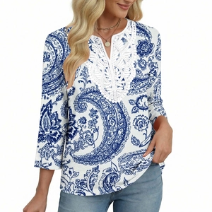 Dettaglio dello scollo a V con pizzo bianco e stampa paisley blu sul top da donna
