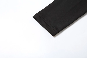 Detailed close-up of double-needle hem stitching on black long sleeve dress fabric