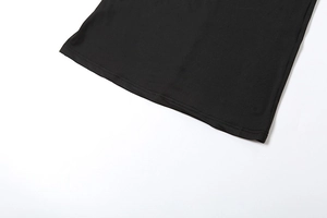 Detail of double-needle stitching on the hem of a black slim-fit ruched dress