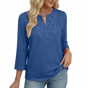 Detail of delicate lace embroidery on V-neckline of a navy blue three-quarter sleeve top