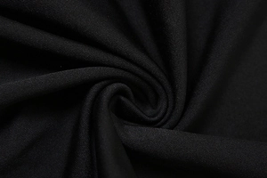 Close-up detail of high-quality black knitted fabric with elastic texture and smooth finish