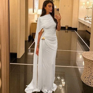 Détail d'une robe de soirée blanche à col montant avec manche cape et anneau doré