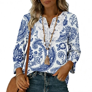 Dettaglio dello scollo a V con ricamo in pizzo bianco e top con stampa paisley blu