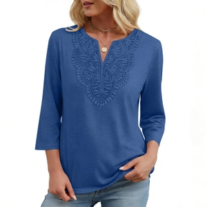 Detailed close-up of the delicate lace embroidery on the V-neckline of a navy blue top