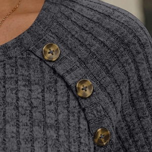 Close-up of ribbed knit grey top featuring retro tortoiseshell buttons and round neckline