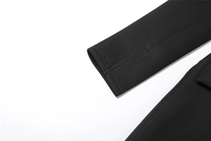 Detailansicht eines schwarzen Langarmkleides mit praktischen Daumenlöchern und Stricktextur
