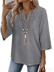 Detail of grey V-neck top showing delicate floral lace embroidery and soft fabric texture
