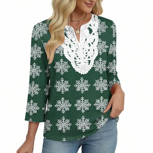 Dettaglio dello scollo a V con pizzo floreale bianco su top stampato verde scuro