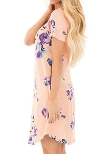 Detail view of pink floral short sleeve dress featuring purple roses and side slit hem