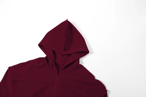 Detail eines weinroten Zip-Hoodies mit Kapuze und präzisen Nähten im modernen Stil