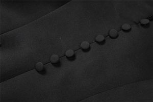 Detailaufnahme von schwarzem Stoff mit eleganten stoffbezogenen Knöpfen und Köperstruktur