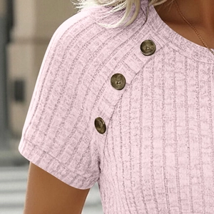 Close-up of pink ribbed knit texture and three decorative buttons on shoulder