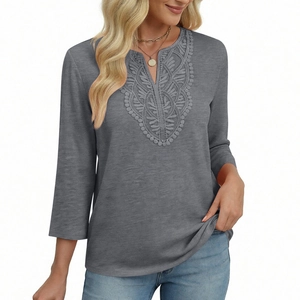 Detail of grey V-neck top showing elegant lace embroidery and soft brushed fabric texture