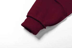 Detailaufnahme der gerippten Bündchen am burgunderroten langärmeligen Strickanzug