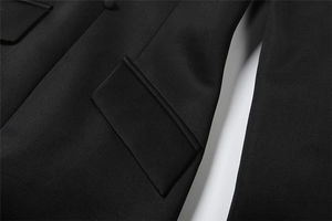Nahaufnahme von Pattentasche und bezogenem Knopf an einem schwarzen Langarmkleid