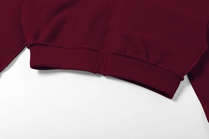 Detail von hochwertigem Reißverschluss und Rippsaum an weinrotem Kapuzenanzug für Damen