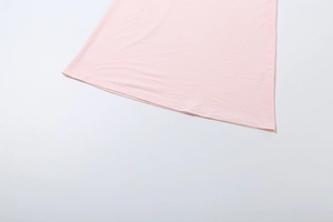 Détail de l'ourlet de la robe en tricot rose clair montrant une double couture précise