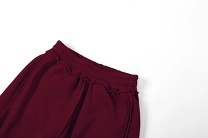 Detail der burgunderroten Jogginghose mit elastischem Kordelzugbund und Ziernähten