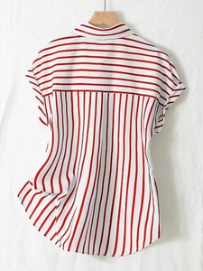 Close-up of red and white striped short sleeve shirt with lapel collar on a wooden hanger