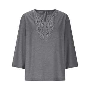 Close-up of V-neckline with delicate geometric lace embroidery on grey women's top