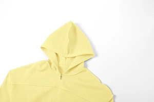 Nahaufnahme von hellgelbem Kapuzenpullover mit Reißverschluss und Strickgewebe