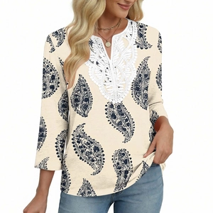 Dettaglio dello scollo in pizzo bianco e stampa paisley blu su tunica beige donna
