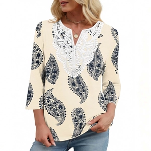 Dettaglio dello scollo a V con pizzo bianco ricamato su camicetta a stampa paisley